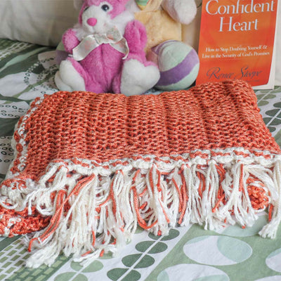 An Orange knitted summer blanket for babies from eri silk -  Download this beautiful silk knitting pattern online from Muezart India 