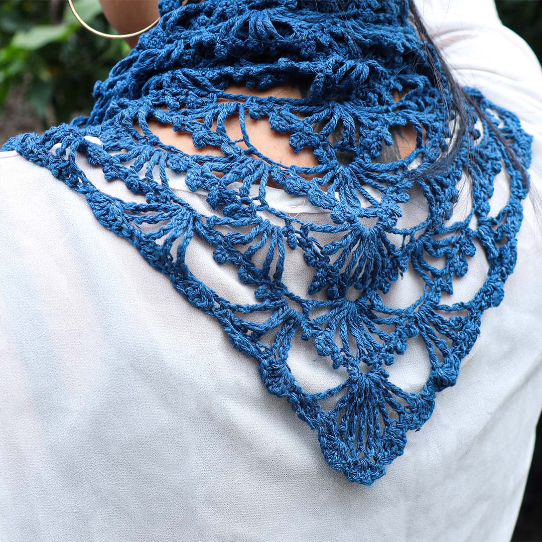 A Women wearing a blue knitted silk scarf from eri silk -  Download this beautiful silk knitting pattern online from Muezart