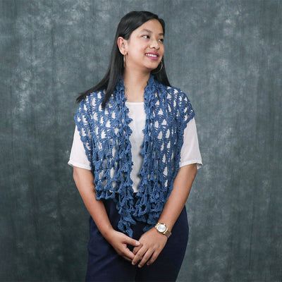 A Women wearing a blue knitted silk scarf from eri silk -  Download this beautiful silk knitting pattern online from Muezart