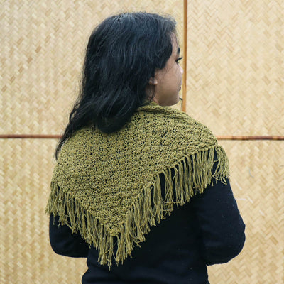 A Women wearing a green knitted silk scarf from eri silk -  Download this beautiful silk knitting pattern online from Muezart